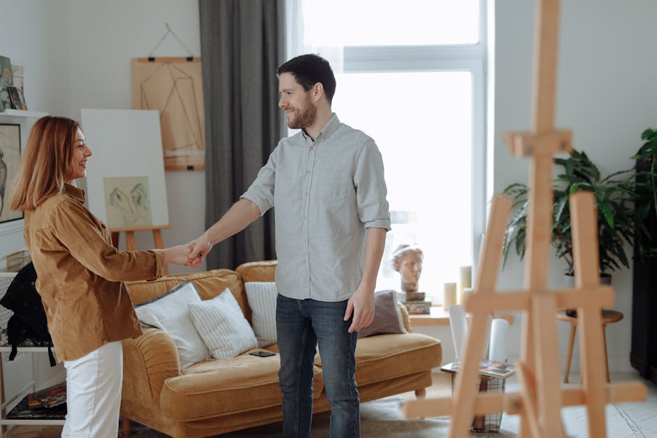 A man and woman greeting each other with a handshake in a modern art studio.