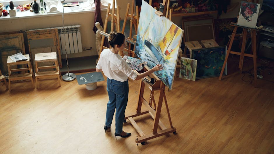 A female artist working on a seascape painting in her art studio.